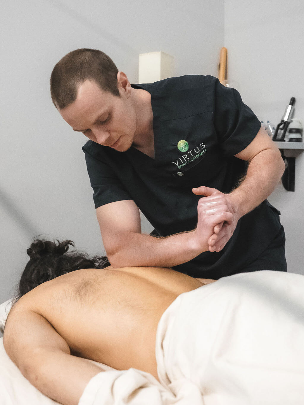Massage therapist Jake treating a patient's upper back