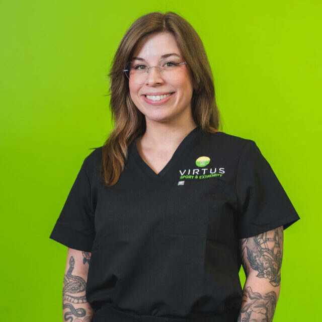 elly-stacy-2026 Elly Stacy smiling wearing black Virtus scrubs, professional portrait