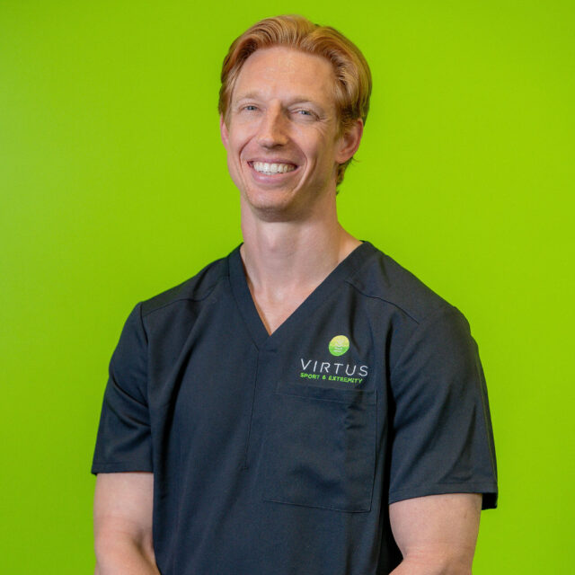 michael-klein-2026 Dr. Michael Klein smiling wearing black Virtus scrubs, professional portrait