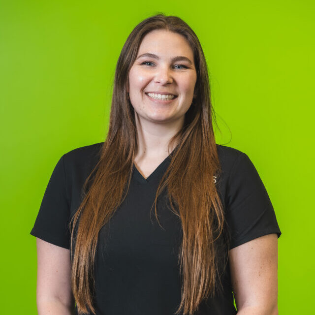rylie-wales-2026 Dr. Rylie Wales smiling wearing black Virtus scrubs, professional portrait