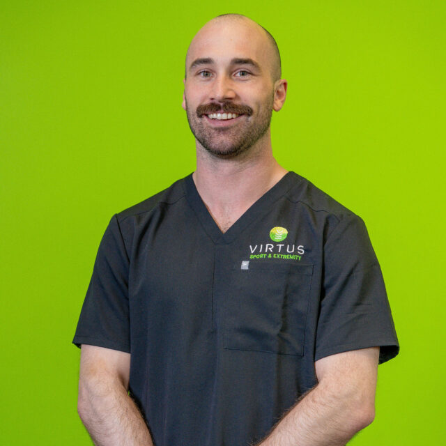 DES05418 Dr. Marshall Just, smiling wearing black Virtus scrubs, professional portrait