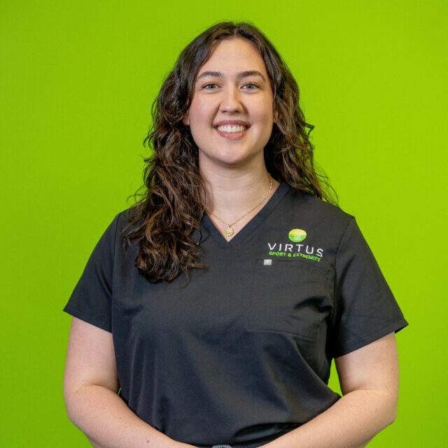 leah-stout-2026 Leah Stout smiling wearing black Virtus scrubs, professional portrait