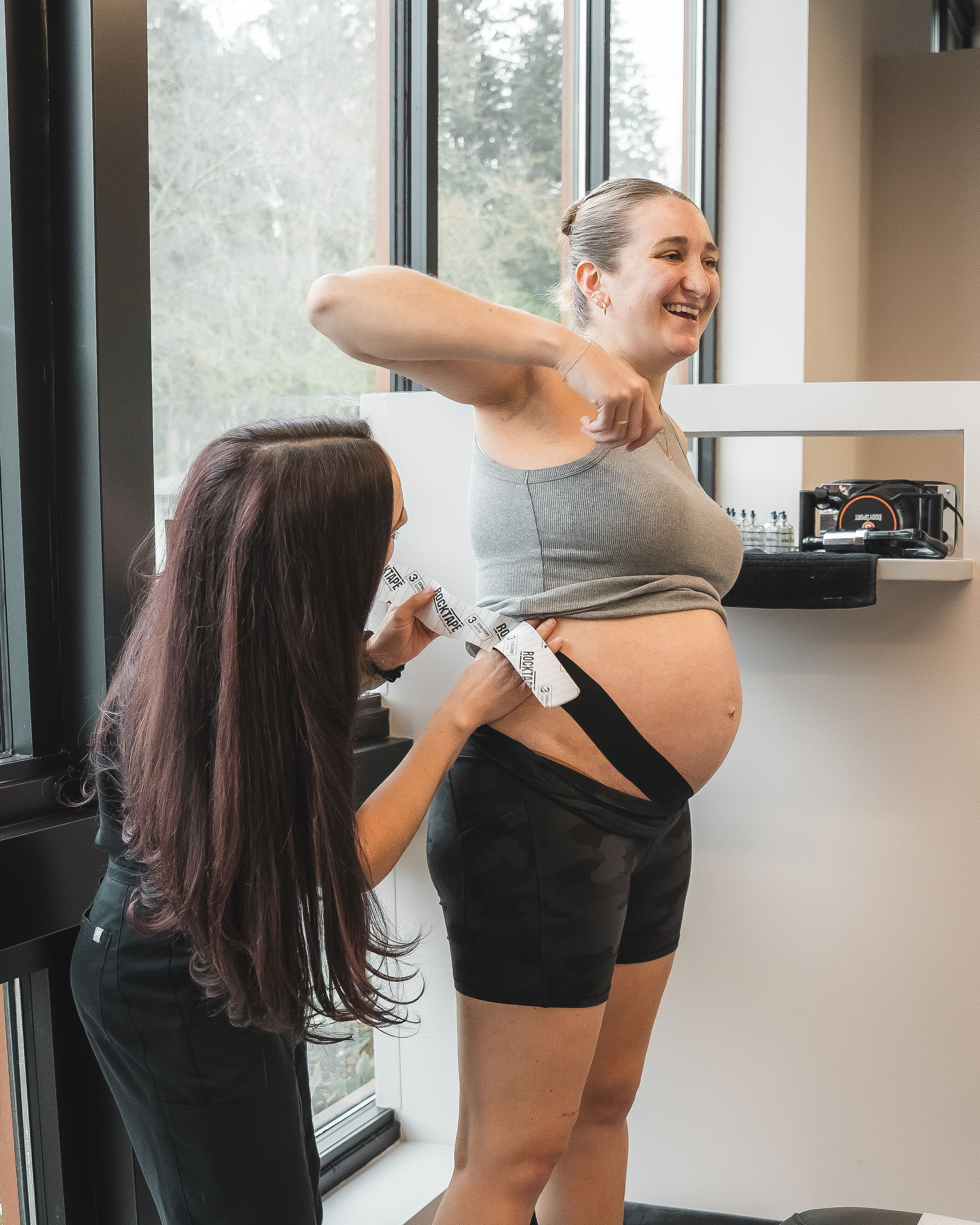 molly-sparks-kinesiology-tape Dr. Molly Sparks placing kinesiology tape on a pregnant patient's belly for support.